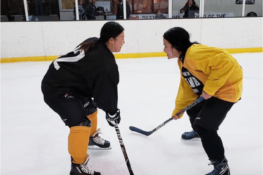 Photo of Melissa and fellow hockey team mate on the ice practicing.
